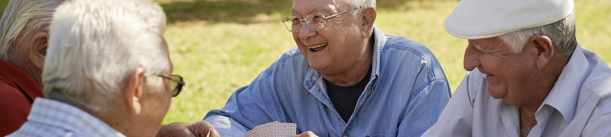 A group of elderly men sit together outdoors